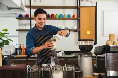 Kahve yapan adam kahve makinesinden espresso shot yapıyor. İtalyan kafeteryasında sütlü kapuçino. Kahve makinesinin ellerini kapat. Müşteri kafeteryası için kahverengi latte yap.