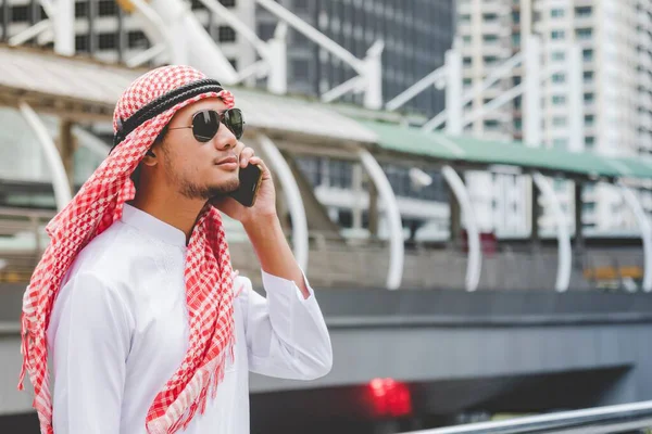 Akıllı telefon uygulaması kullanan İslami portre ajandası gündem gündemi telefon tutan Müslüman modern uae şehrine odaklanıyor. Arap erkekleri başörtüsü takıyor. Başörtüsü Müslüman resmi elbise. Çevrimiçi teknoloji yaşam tarzı.