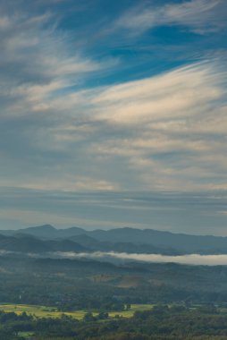 Dikey Güzel Dağ manzarası sisli rüzgarlı dağ sıraları yeşil Asya manzarası çiftliği. Dikey İnanılmaz Peyzaj Dağları yeşil çayır beyaz bulut mavi gökyüzü gün doğumu. Kırsal manzara