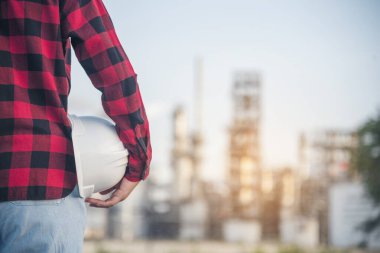 Rafineri kadın mühendis petrol endüstrisinin elleri işçi kaskını tutuyor. Rafineri endüstrisi mühendisliği. Mühendis kadın elleri inşaat mühendisliği için kaskını tutuyor.