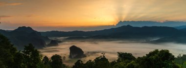 Banner Güzel Dağ manzarası sisli dağ yeşili sabah güneşi. Güneşin doğuşunda muhteşem manzara dağı yeşil tropikal orman ağacı. Fotokopi alanına sahip Banner Ormanı güneş ışığı manzarası