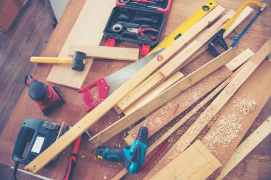 DIY el işi ahşap yığını marangoz ahşap işçiliği masasına itiraz ediyor. Cetvel ölçümlü mimar aletleri ile çekiç ev geliştirme ekipmanları. Ahşap marangoz inşaat atölyesini tamir ediyor.