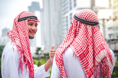 Arap Müslüman erkekler takım çalışanları olarak birlikte konuşuyorlar. Dijital pazarlama Arap grubu modern müslüman BAE şehrine danışmayı tartışıyor. Mutlu Girişimci Asyalı insanlar toplanan gülümseyen takımlar