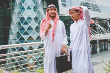 Arap Müslüman erkekler takım çalışanları olarak birlikte konuşuyorlar. Dijital pazarlama Arap grubu modern müslüman BAE şehrine danışmayı tartışıyor. Mutlu Girişimci Asyalı insanlar toplanan gülümseyen takımlar