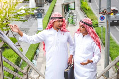 Arap Müslüman erkekler takım çalışanları olarak birlikte konuşuyorlar. Dijital pazarlama Arap grubu modern müslüman BAE şehrine danışmayı tartışıyor. Mutlu Girişimci Asyalı insanlar toplanan gülümseyen takımlar