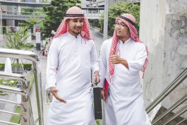 Arap Müslüman erkekler takım çalışanları olarak birlikte konuşuyorlar. Dijital pazarlama Arap grubu modern müslüman BAE şehrine danışmayı tartışıyor. Mutlu Girişimci Asyalı insanlar toplanan gülümseyen takımlar