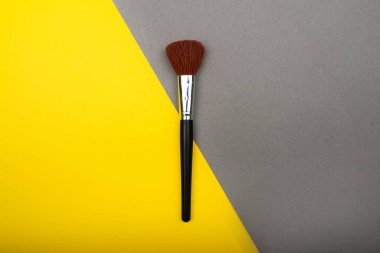 Kozmetik fırça sarı ve gri arka planda izole edilmiş. Pop-art konsepti.