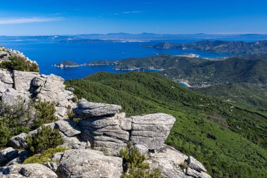 Işıl ışıl deniz manzarası, yemyeşil yeşil arazi, kayalık kıyı şeritleri, berrak mavi sular ve seyahat ve doğa fotoğrafçılığı için mükemmel doğal güzellik Elba Adası 'nın nefes kesici manzarası.