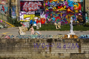 Viyana, Avusturya - 4 Ekim 2025 İnsanlar Donaukanal 'ın grafiti kaplı nehir kıyısında vakit geçirir..