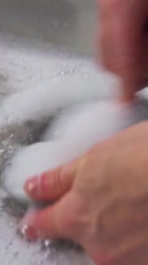 Çelik bir lavaboda fırçayla el yıkama.