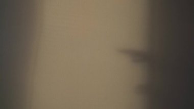 Çimento duvarında uzanan ellerin gölgeleri.