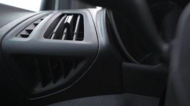 Arabanın torpido gözündeki havalandırmayı ayarlayan eli kapat..