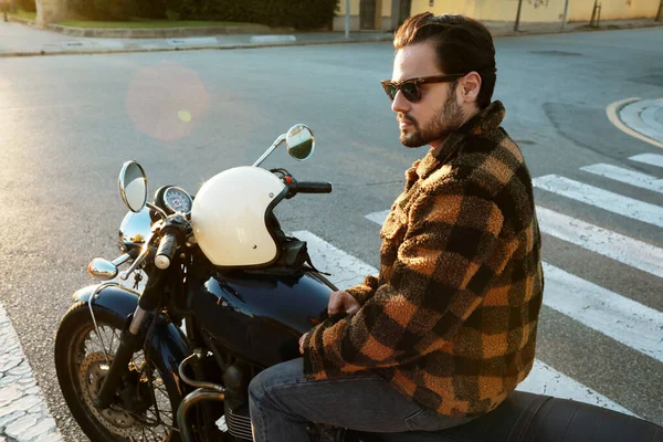 Oldal portré fiatal szakállas motoros férfi motorkerékpár szabadban a város utcáin. — Stock Fotó