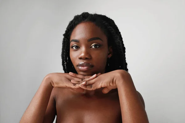 Joyeuse jeune femme africaine noire devant le mur de fond blanc. Isolé. — Photo