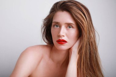 Sağlıklı ve temiz ciltli genç bir kadının güzel yüzüne yakın çekim. Beyaz arkaplanda izole.