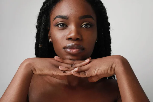 Zbliżenie portret młodej czarnej atrakcyjnej kobiety, pozowanie na białym tle. Koncepcja pielęgnacji skóry. — Zdjęcie stockowe