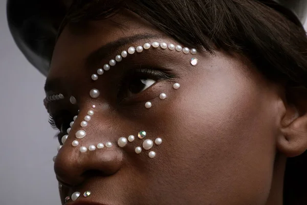 Gros plan portrait de jeune femme noire avec de petites perles sur la peau. maquillage créatif. — Photo