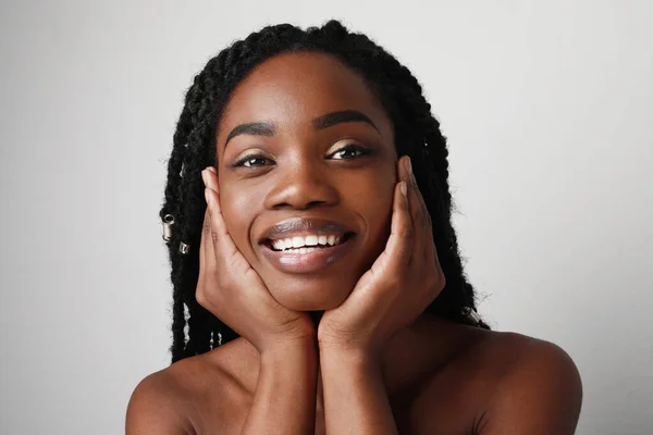 Close-up de jovem mulher atraente preto com belo sorriso, posando sobre fundo branco. Conceito de cuidados da pele. — Fotografia de Stock
