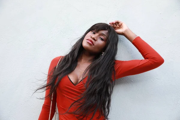 Jovem mulher africana bonita, cabelo comprido vestindo vestido vermelho andando ao ar livre. — Fotografia de Stock