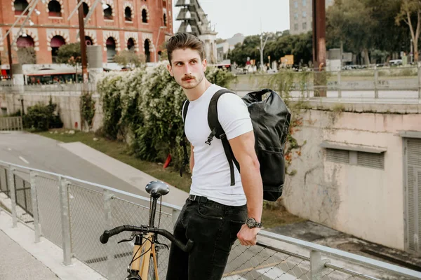 El joven en ropa casual está posando con su bicicleta al aire libre. — Foto de Stock