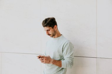 Genç yakışıklı hippi akıllı telefonunu kullanıyor. Açık havada portre.