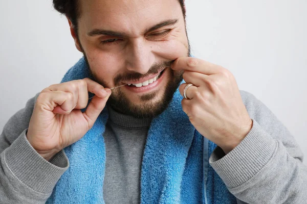 Close-up de homem barbudo atraente enquanto usa fio dental, conceito de preparação. — Fotografia de Stock