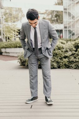 Açık havada poz veren kendinden emin ve başarılı genç bir iş adamı. İş ve insanlar.