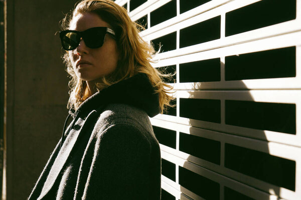 Portrait of young woman wearing sunglasses posing outdoor.