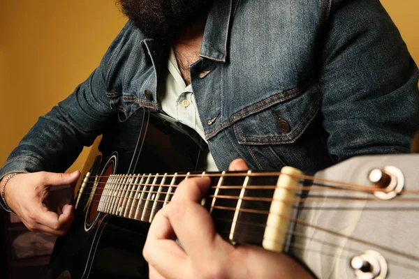 Beskuren bild av människan öva på att spela akustisk gitarr. — Stockfoto