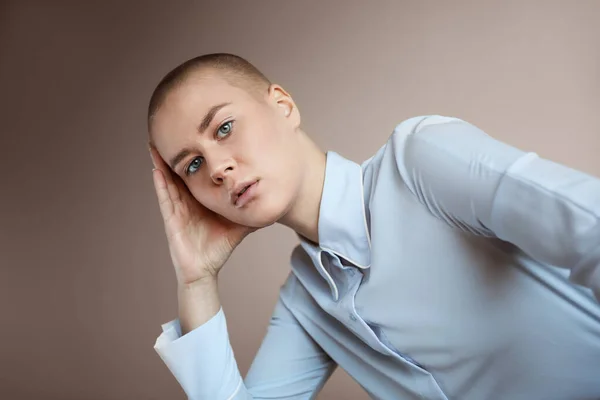 Portrait of a beautiful bald woman wearing blue clothes. Posing at the studio. — Foto Stock