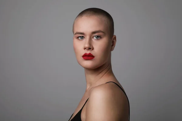 Retrato de una mujer hermosa y calva mirando a la cámara con labios rojos. —  Fotos de Stock