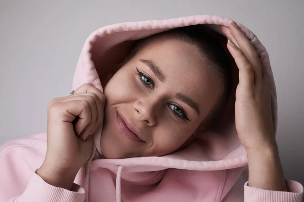 Close-up shot of young happy bald woman wearing pink hoodie posing at studio. — Stock fotografie