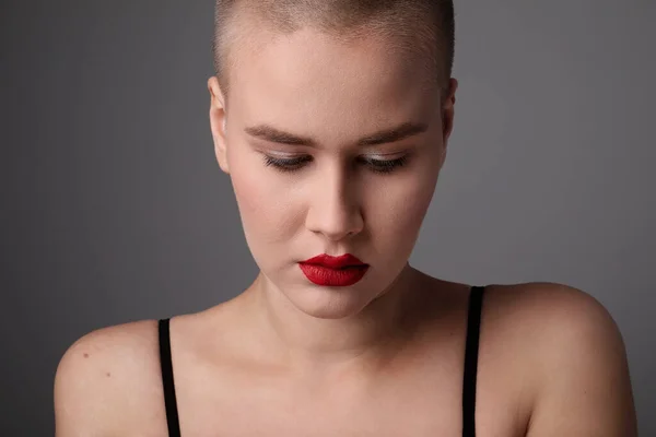 Portrait of a beautiful and bald woman looking aside with red lips. — Stockfoto