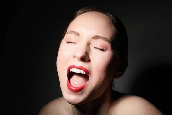 Close-up portret van gelukkige jonge vrouw, poseren over zwarte muur. — Stockfoto