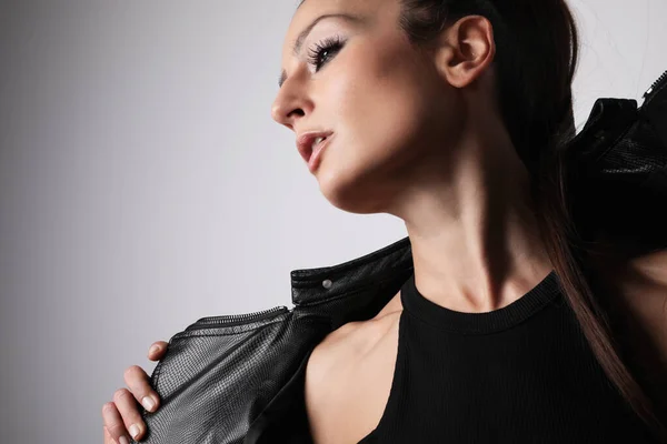 Captura de cabeça de mulher atraente vestindo roupas pretas. Fundo de luz. — Fotografia de Stock