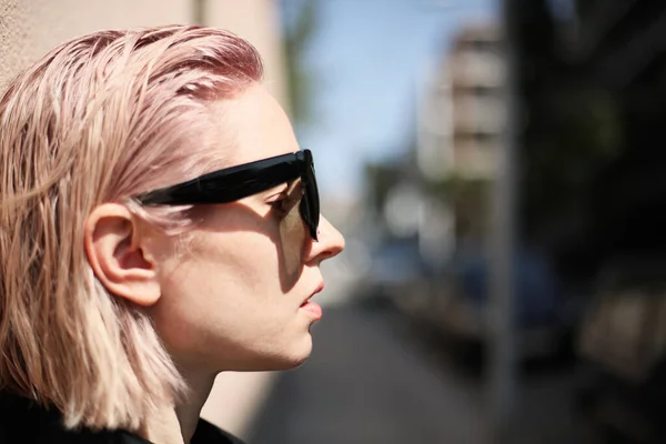 Schöne junge Mädchen mit rosa lockigen Haaren, Straßenstil, Hipster-Mädchen, im Freien. — Stockfoto