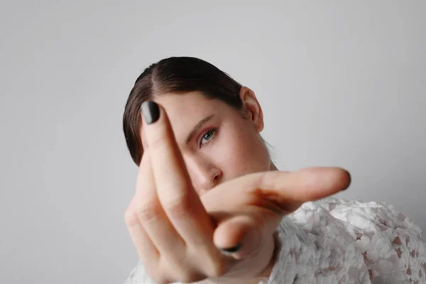 Retrato de una hermosa mujer joven señalando con el dedo usando vestido blanco. —  Fotos de Stock