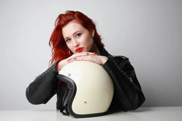Mulher motociclista atraente com cabelo vermelho, posando com capacete branco. — Fotografia de Stock