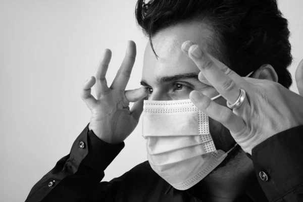 Egy fekete-fehér közelkép egy emberről, aki orvosi maszkot visel.. — Stock Fotó