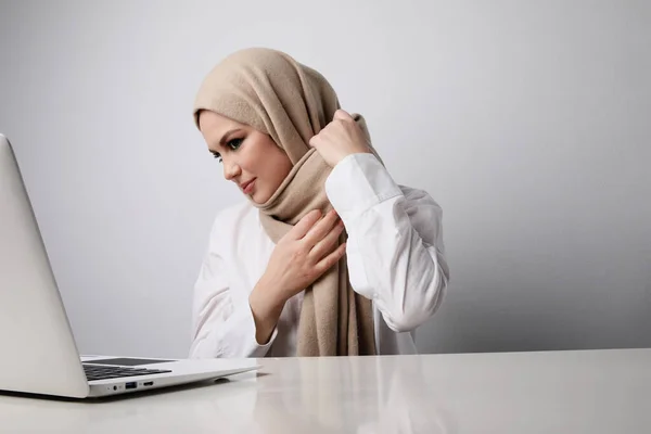 用笔记本电脑工作的年轻快乐的穆斯林妇女的头像。被隔离了. — 图库照片