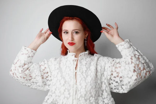 Mulher bonita e jovem com cabelo vermelho, enquanto em pé sobre fundo branco. — Fotografia de Stock