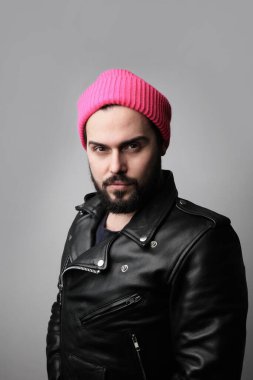 Genç, sakallı, pembe şapkalı bir adam. Dikey.