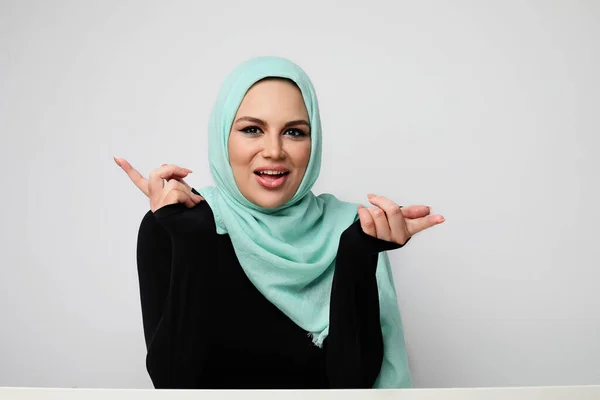 Retrato de jovem mulher muçulmana feliz vestindo hijab verde. Fundo de luz. — Fotografia de Stock