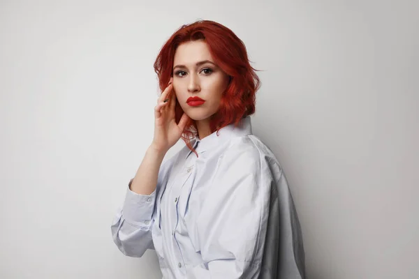 Mulher caucasiana jovem com cabelo vermelho posando sobre fundo cinza. Isolados. — Fotografia de Stock