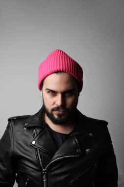 Pembe şapkalı, vahşi, sakallı bir adamın dikey portresi..