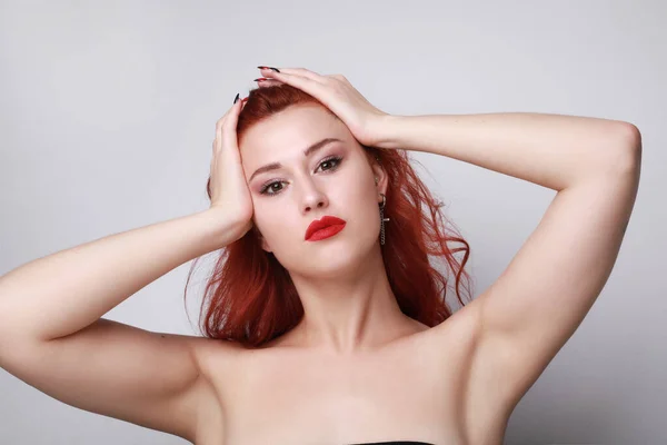 Närbild av ung kvinna med rött hår poserar över grå bakgrund. Isolerad. — Stockfoto