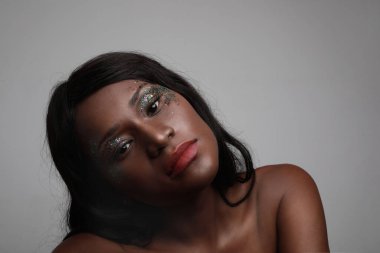 Gri duvarda sağlıklı derili Afrikalı Amerikalı genç bir kadının portresi..