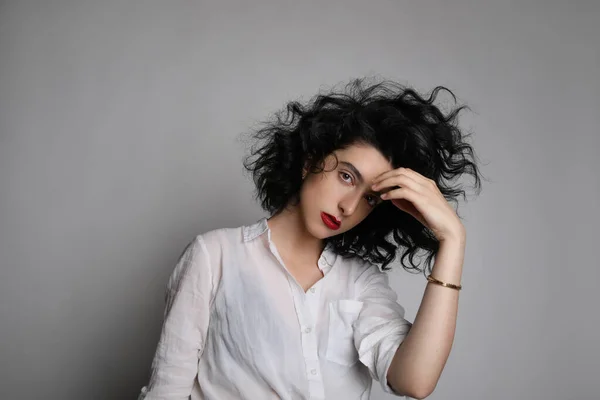Függőleges portré fiatal nő göndör haj pózol át fehér fal. — Stock Fotó