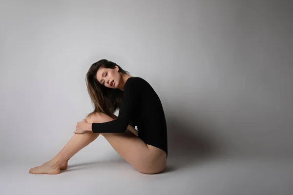 Ung fitness kvinna, bär svart kropp, poserar i studion. — Stockfoto