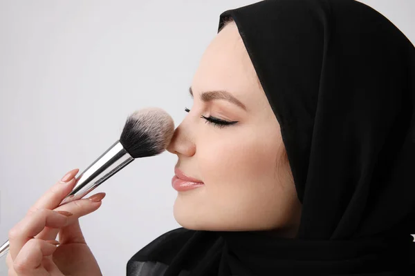 Close-up de mulher muçulmana usa hijab preto fazendo sua rotina de maquiagem. — Fotografia de Stock